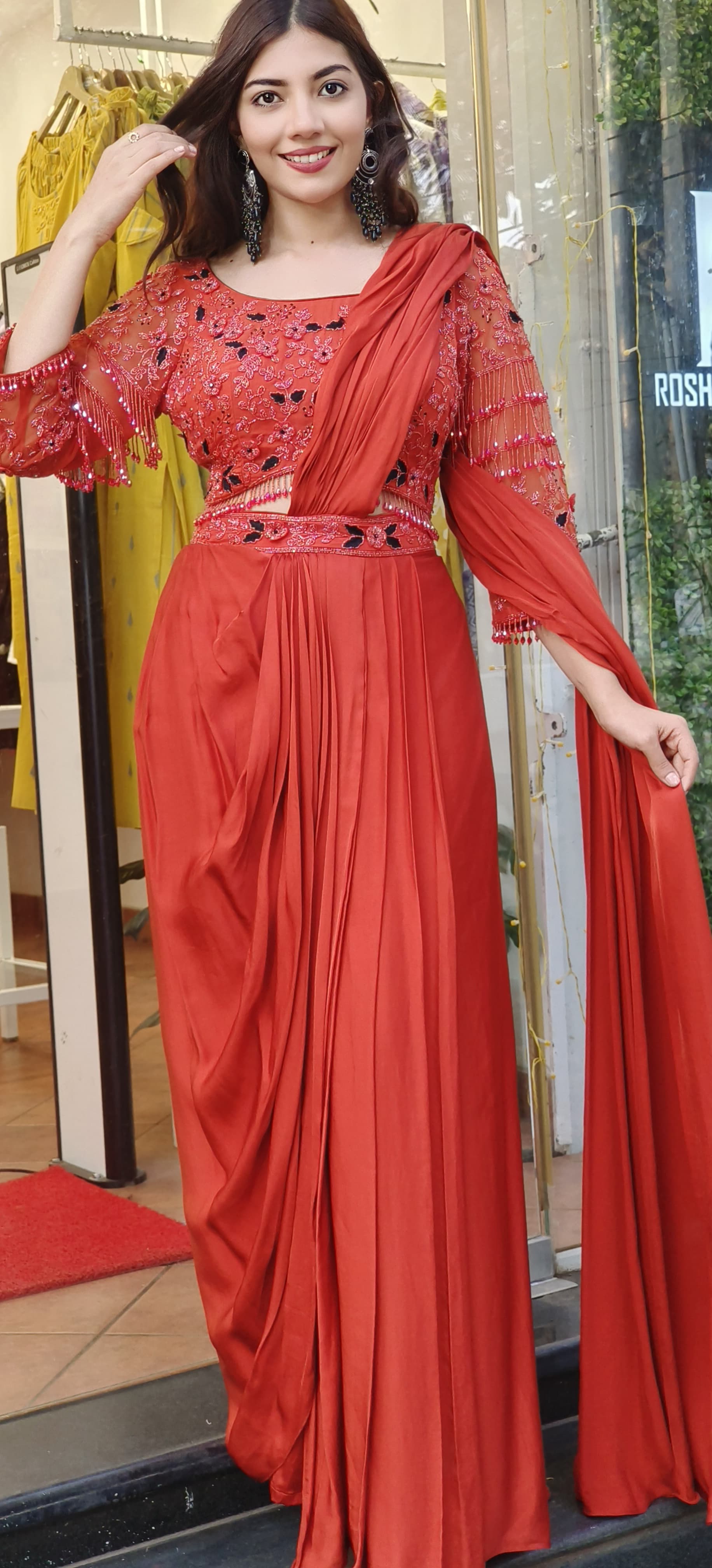 Rust Crystal-Embellished Crepe Dhoti Saree Set A designer ensemble featuring a heavily adorned crystal work blouse paired with a trendy drape dhoti-style saree DRY WASH-ONLY ON ORDERS DISPATCHING AFTER 30 DAYS -