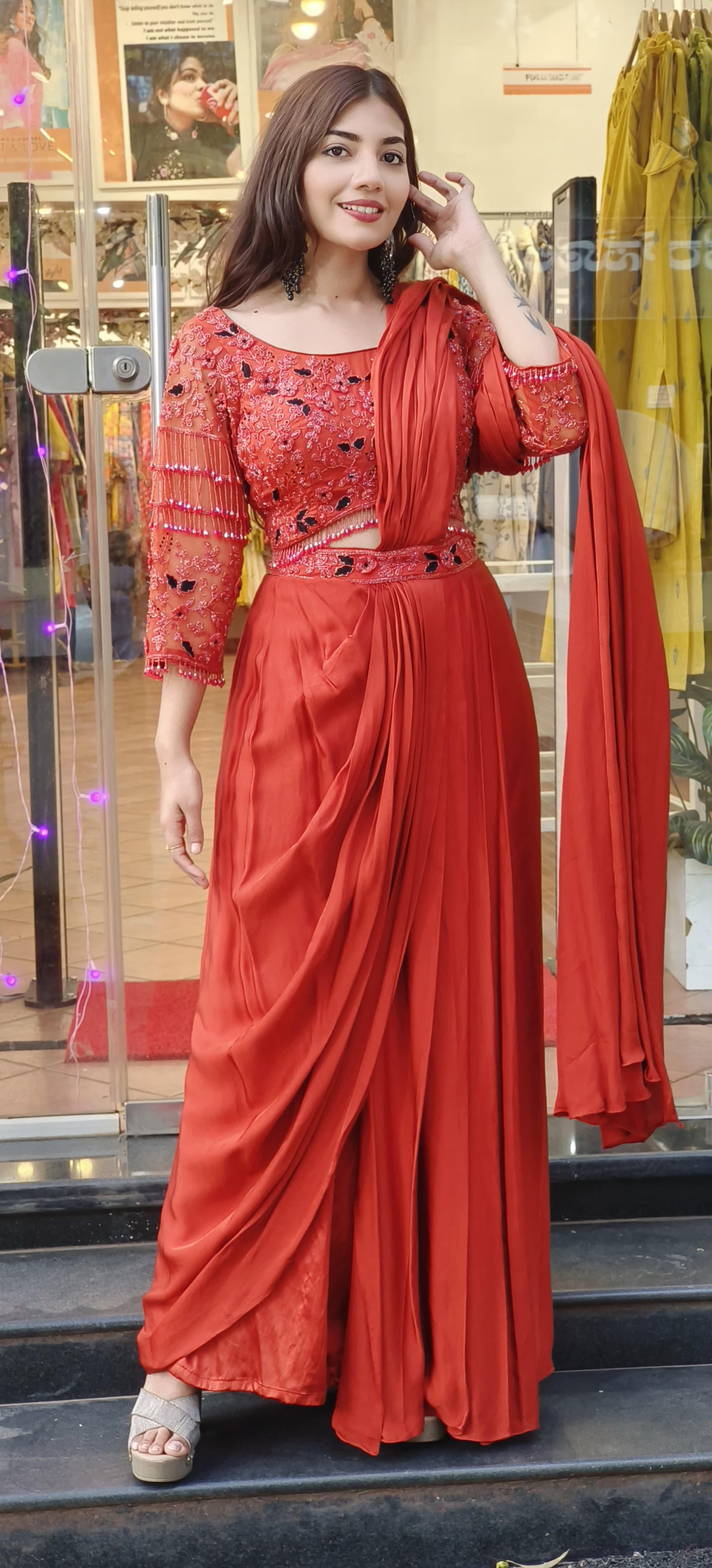 Rust Crystal-Embellished Crepe Dhoti Saree Set A designer ensemble featuring a heavily adorned crystal work blouse paired with a trendy drape dhoti-style saree DRY WASH-ONLY ON ORDERS DISPATCHING AFTER 30 DAYS -