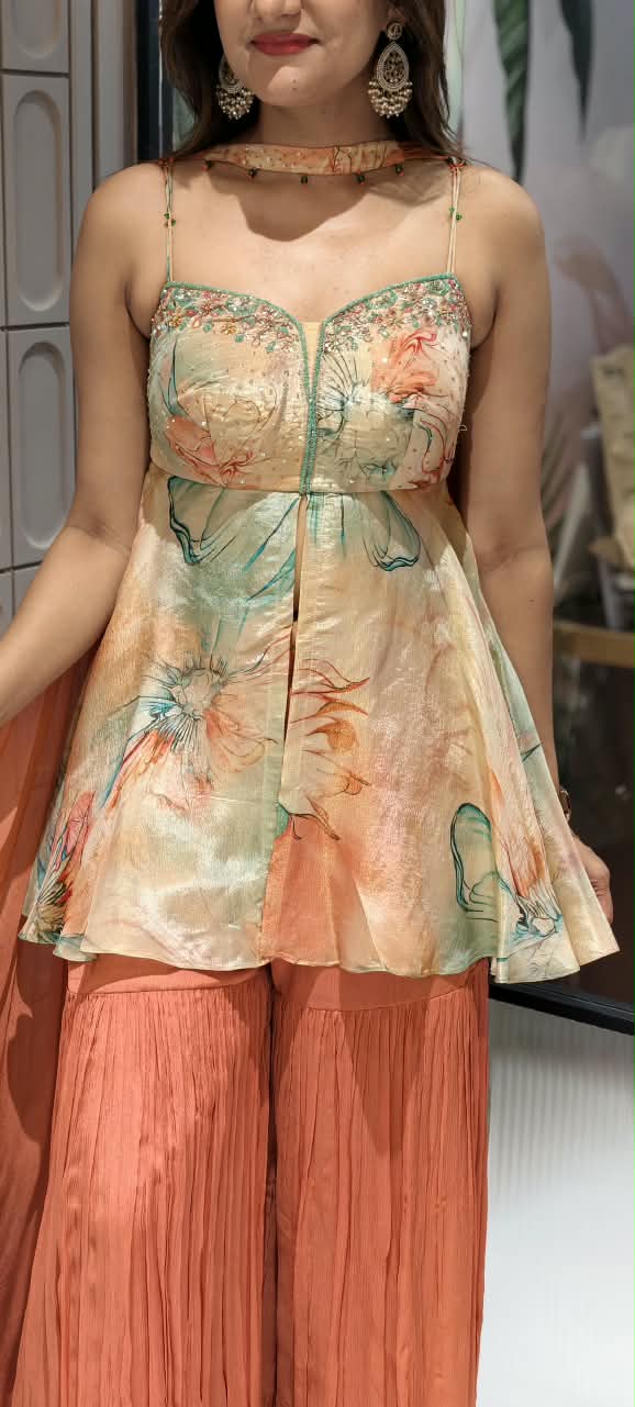 Soft Peach & Coral Floral Printed Noodle Strap Peplum Tunic Set with Pleated Sharara & Beaded Chowker Dupatta- 12759