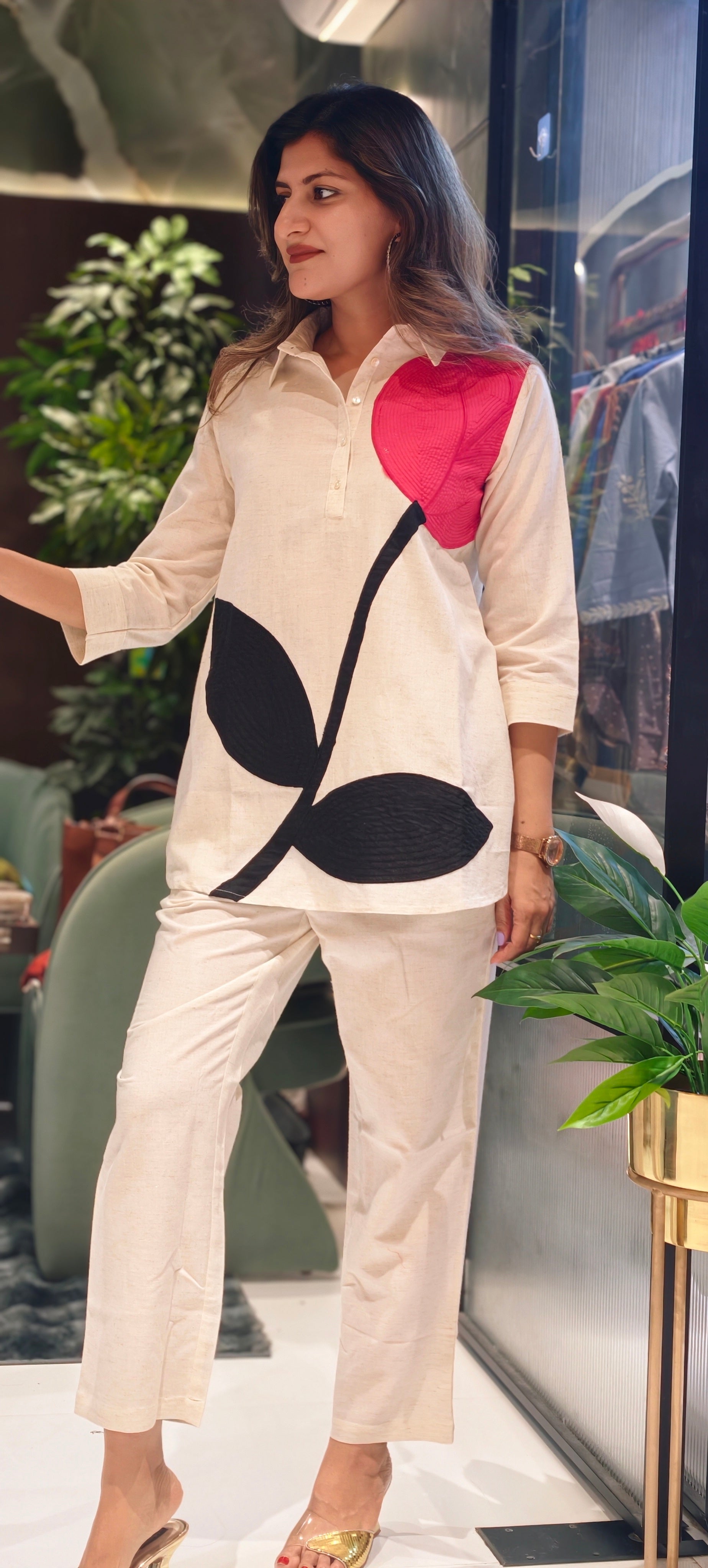 Woman wearing a stylish outfit with a large abstract design in a casual setting.