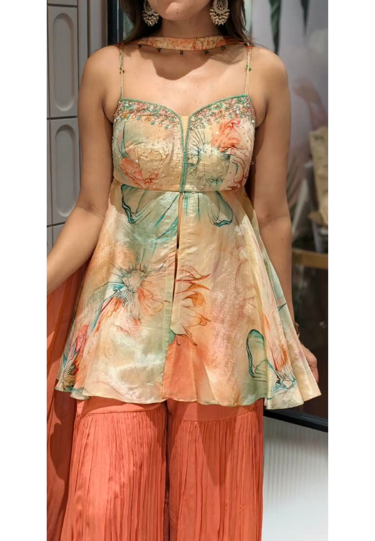 Soft Peach & Coral Floral Printed Noodle Strap Peplum Tunic Set with Pleated Sharara & Beaded Chowker Dupatta- 12759
