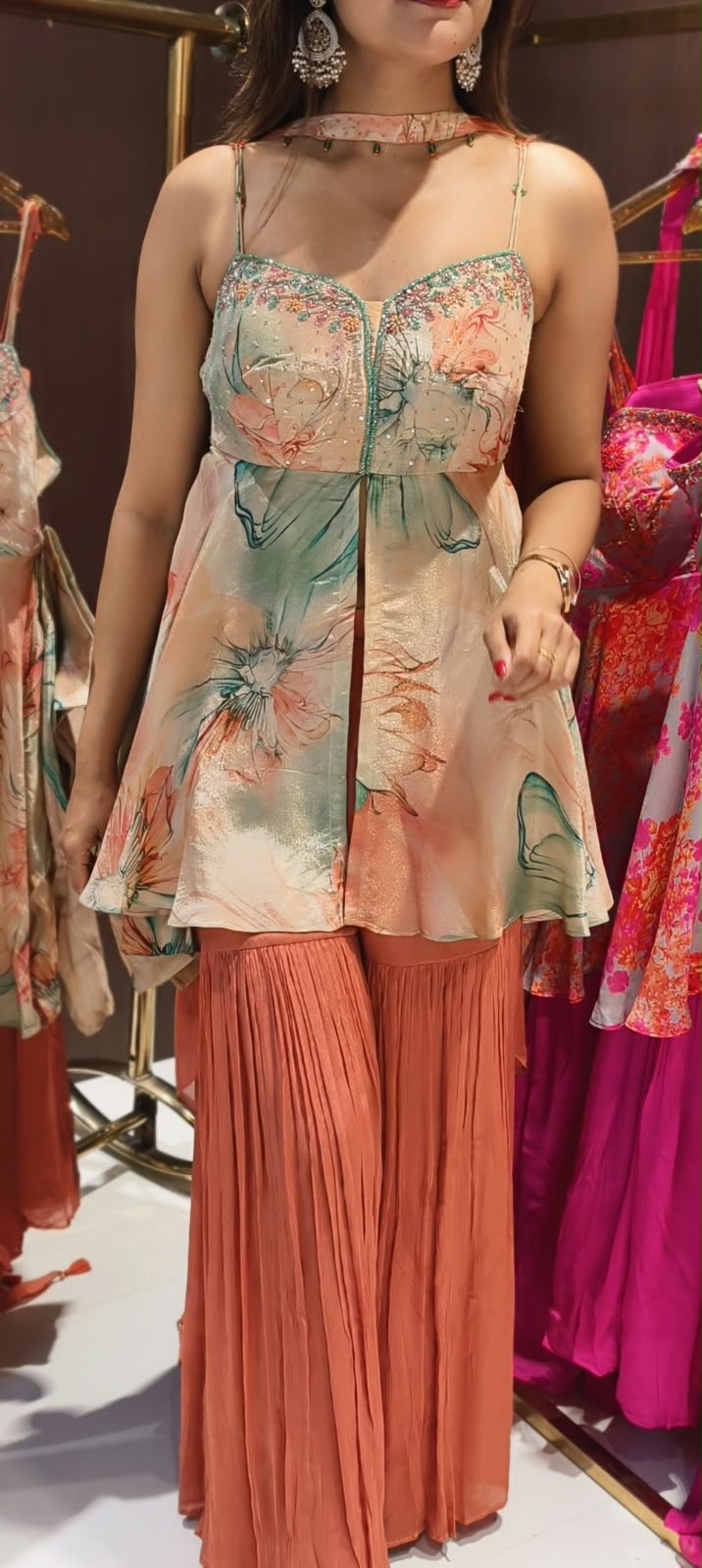 Soft Peach & Coral Floral Printed Noodle Strap Peplum Tunic Set with Pleated Sharara & Beaded Chowker Dupatta- 12759